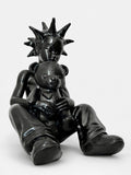 Black sculpture of a figure holding a teddy bear on a white background