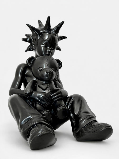 Black sculpture of a figure holding a teddy bear on a white background