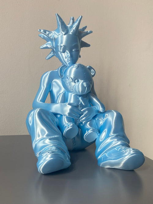 Blue metallic statue of a figure with a crown on a plain background